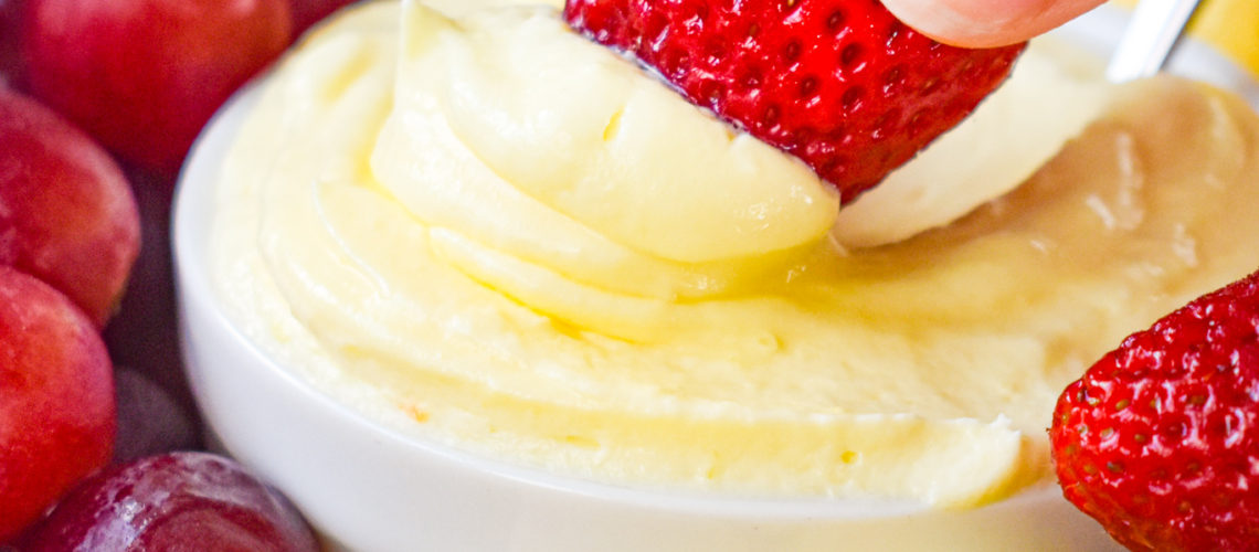 Strawberry getting scooped into Easy Lemon Fruit Dip