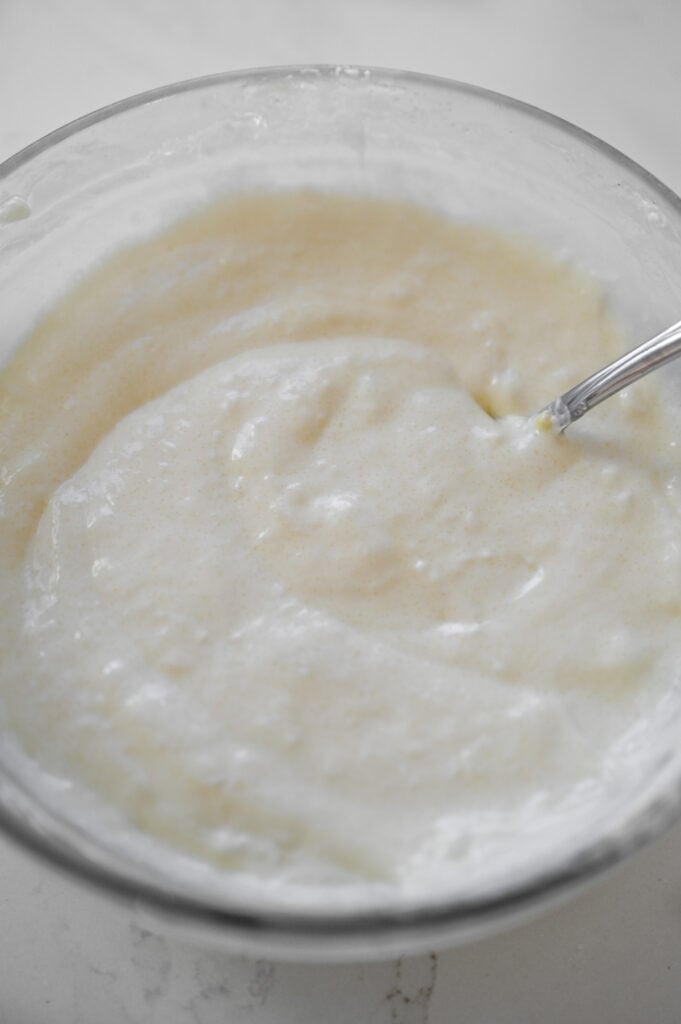 A smooth cream cheese filling in a clear glass bowl.
