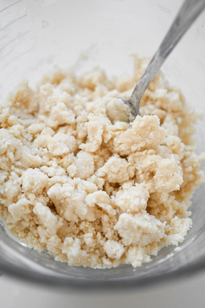 A fork mixing up cake mix and butter to form a crumb topping.