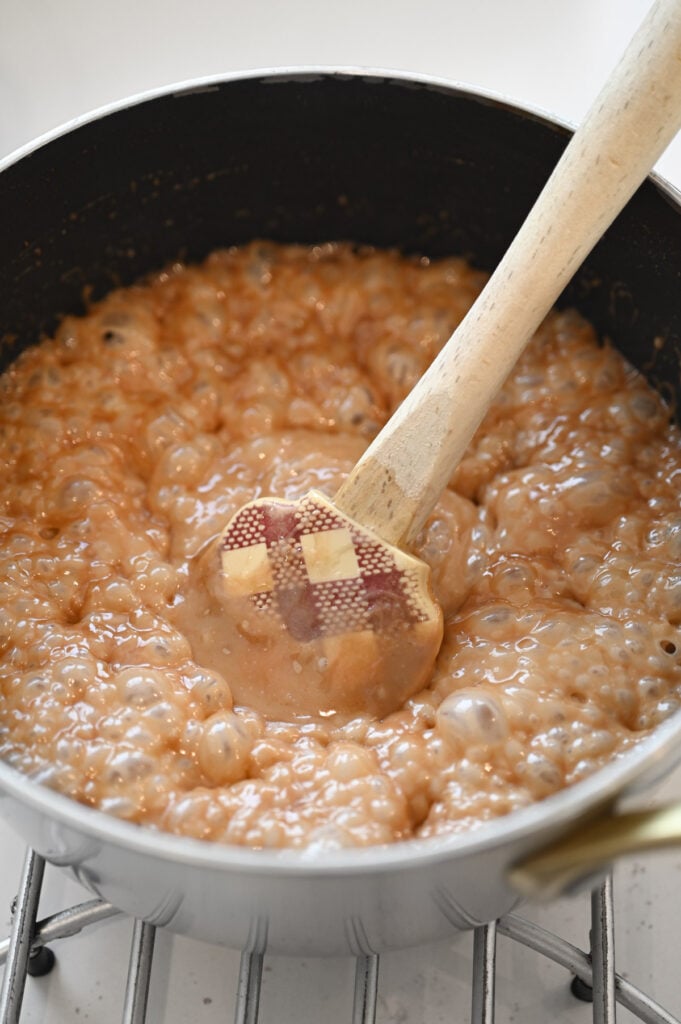 A saucepan with a brown boiling mixture in it.