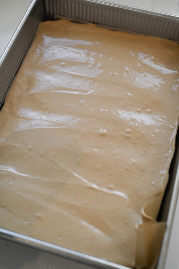 A 9x13-inch pan of brownies with a layer of nougat on top.