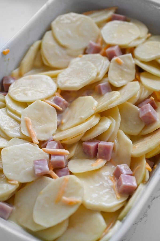 Scalloped potatoes and ham mixed up and ready to be baked.
