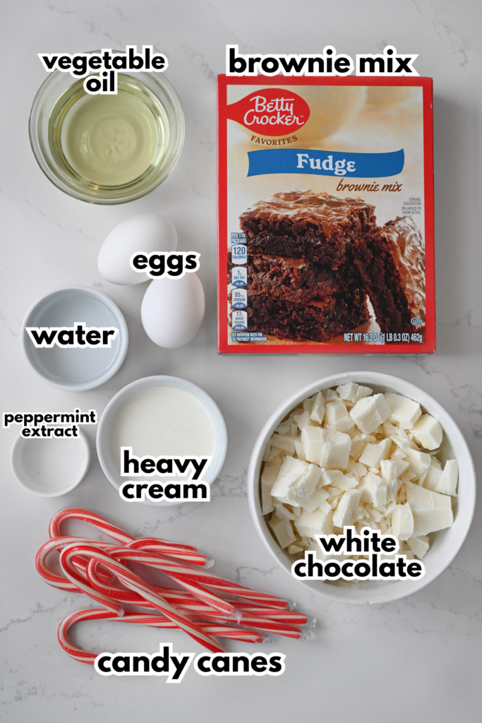 The ingredients needed to make peppermint bark brownies including a boxed brownie mix on a white background.