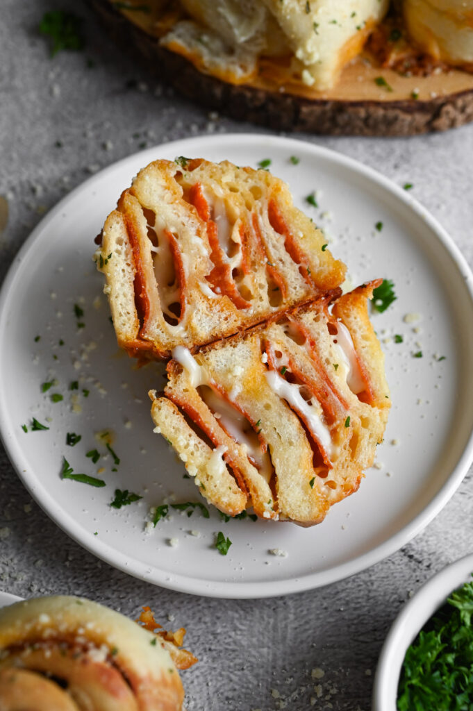 A pepperoni roll cut in half to show the melted cheese and pepperoni.