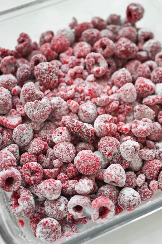 Sugar and cornstarch mixed with raspberries spread into a square baking dish.