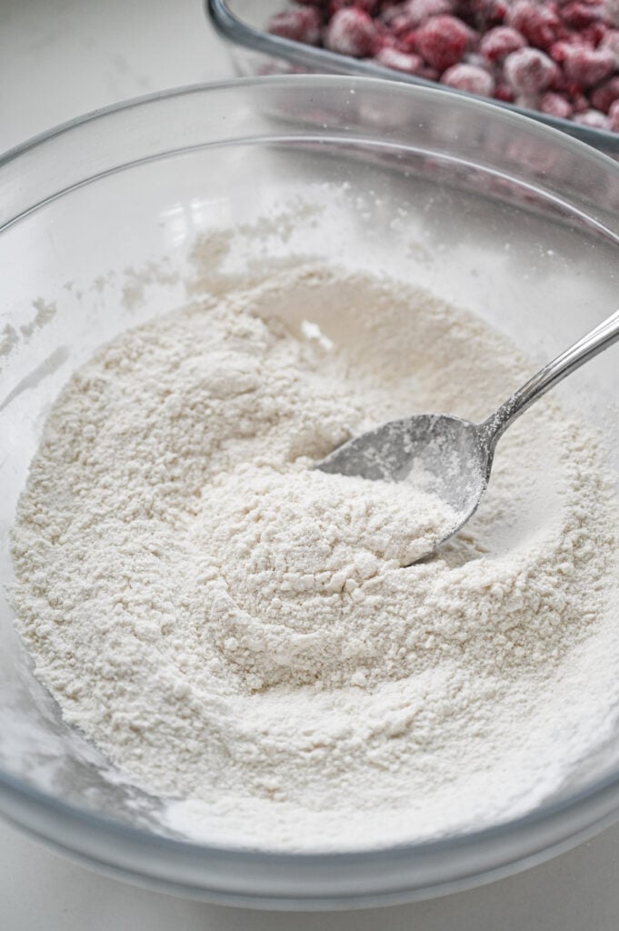 The dry ingredients for a cobbler topping in a clear glass bowl.
