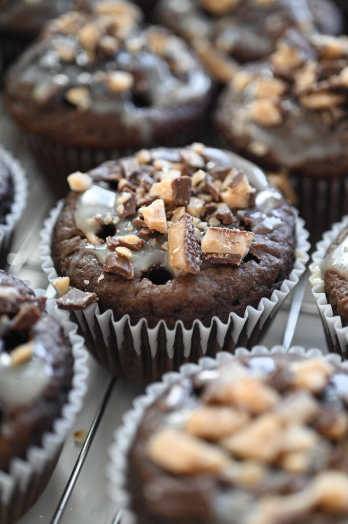 A chocolate cupcake with chopped toffee bits on top.