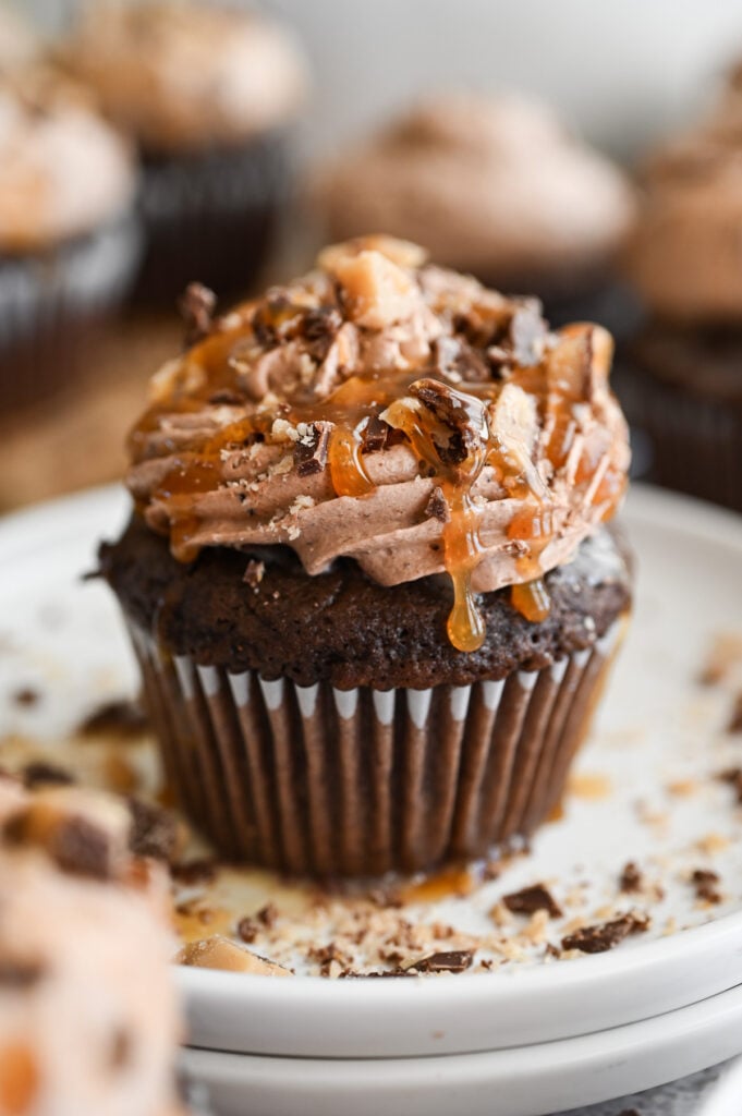 A better than anything cupcake with caramel dripping down the side of it.