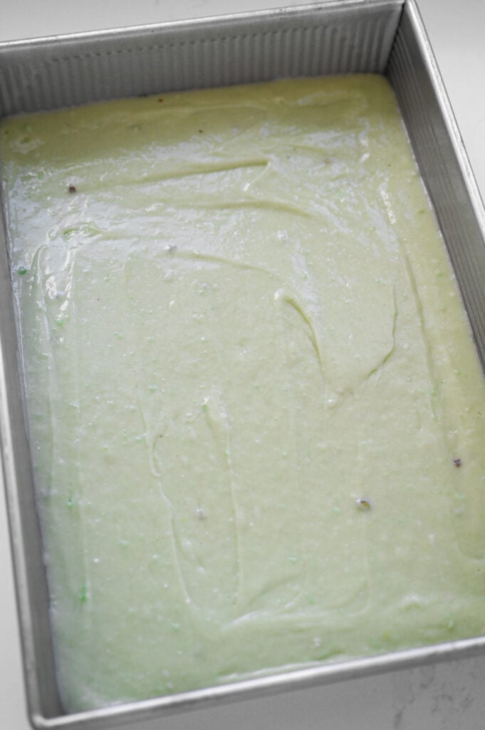 Light green cake batter poured into a 9x13 inch pan.