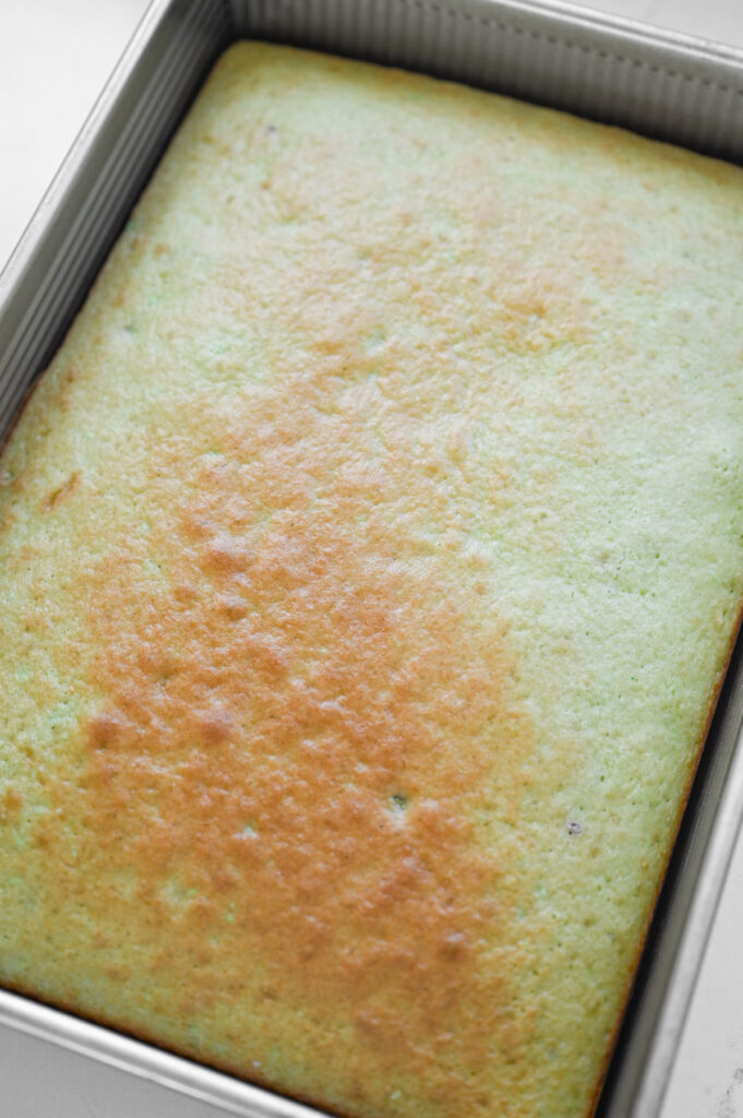 A baked pistachio cake in a 9x13-inch pan.