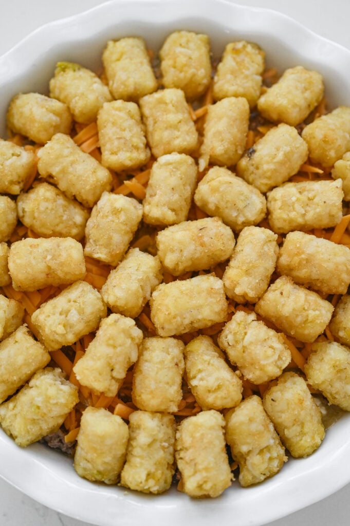 Round tater tot casserole ready to go into the oven.