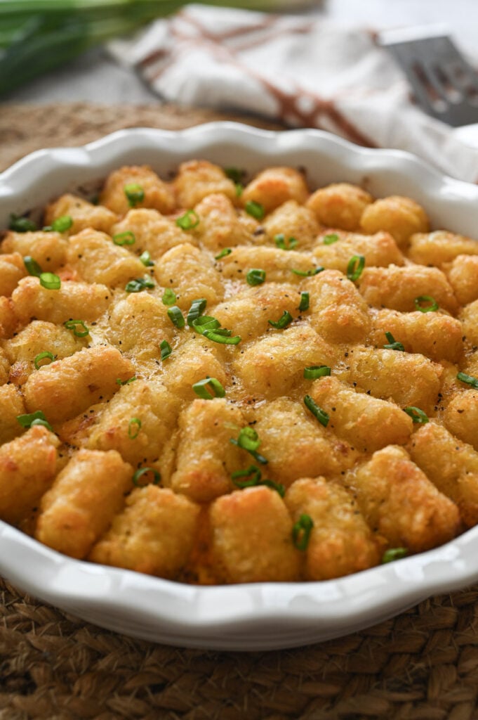 Freshly baked tater tot casserole with sliced green onions on top.