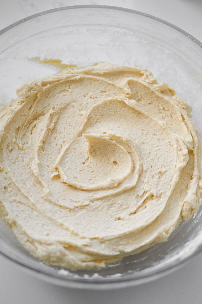 A vanilla batter mixed up in a clear glass mixing bowl.