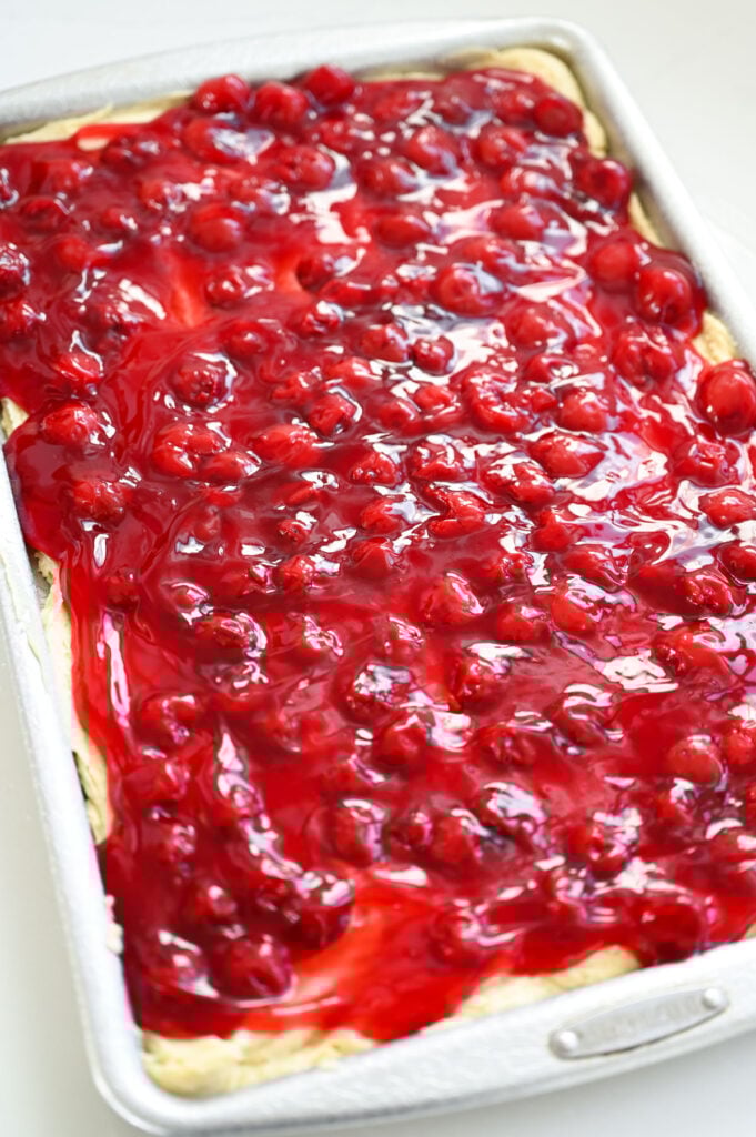 Cherry pie filling spread out over a layer of batter.