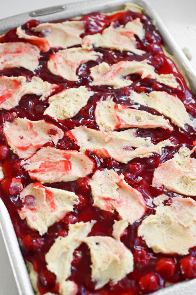 Batter spread on top of cherries.