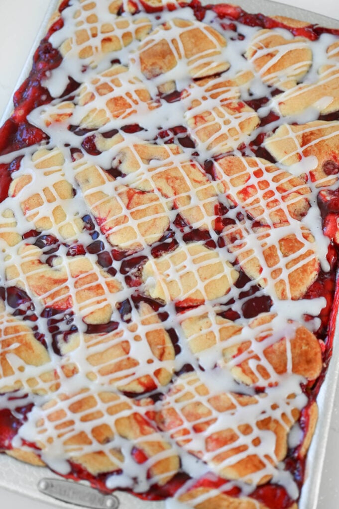 Baked cherry dessert with an icing drizzle on top.