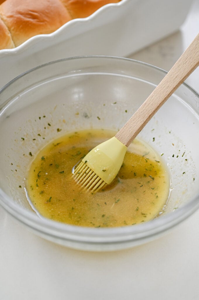 A small mixing bowl with melted butter and seasonings.