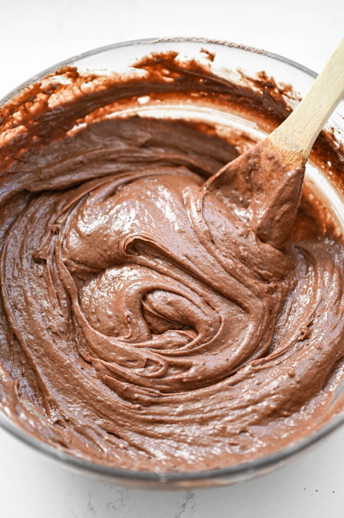 Chocolate cake batter mixed up in a clear bowl.