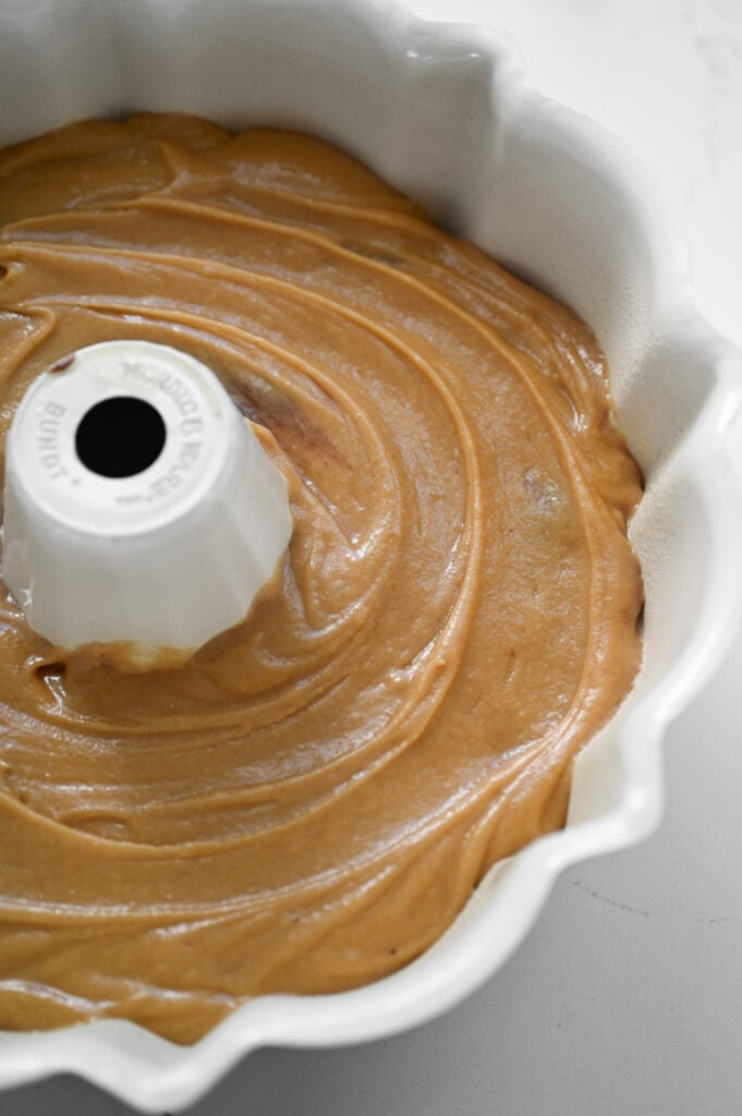 Peanut butter batter spread into a bundt cake pan.