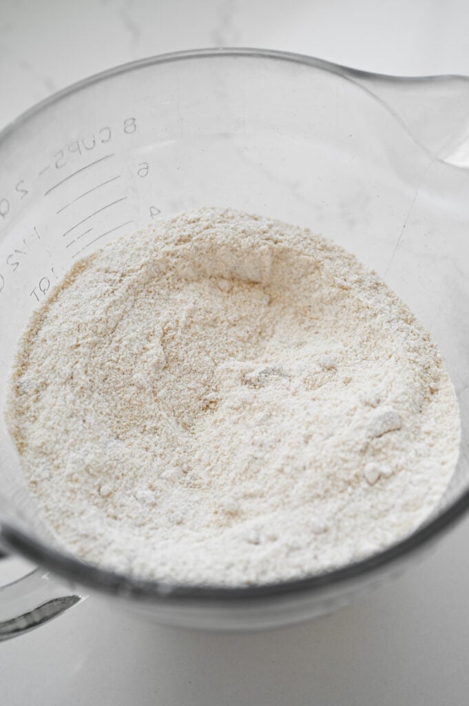 Dry ingredients for a cake mixed together in a clear mixing bowl.