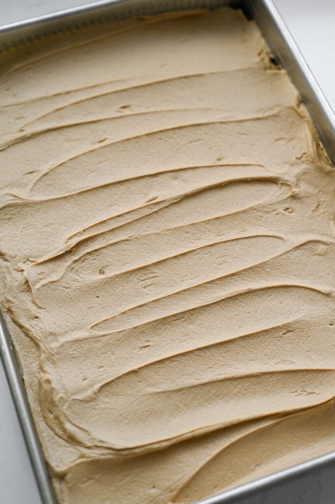 A sheet cake with frosting spread overtop.