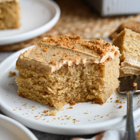 A piece of Biscoff cake on a white plate.