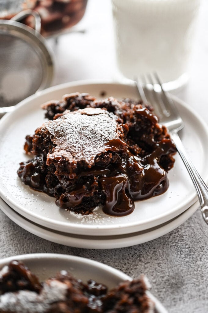 A spoonful of brownie cobbler on a white plate.