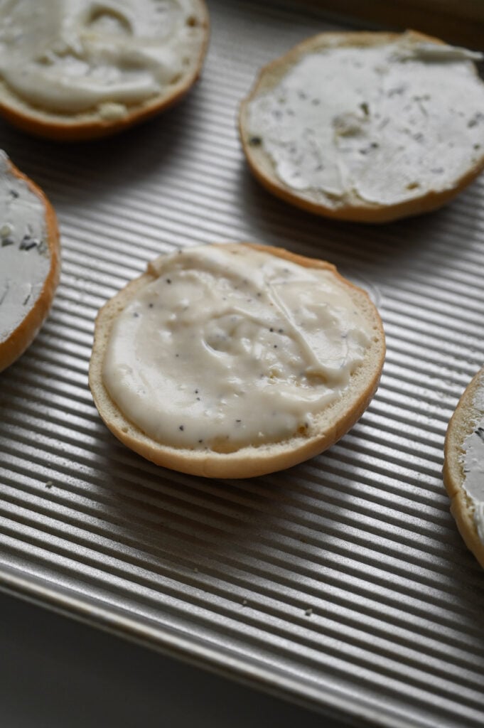 A bagel with gravy spread on top.