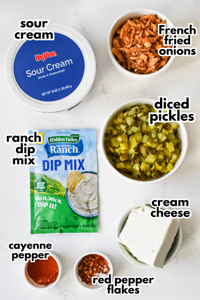 The ingredients needed to make a fried pickle dip laid out on a countertop with labels.