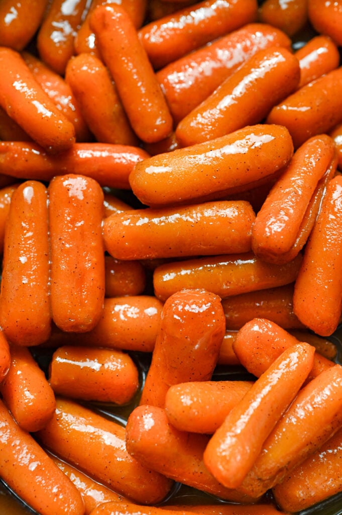 A close-up of glossy glazed brown sugar carrots.
