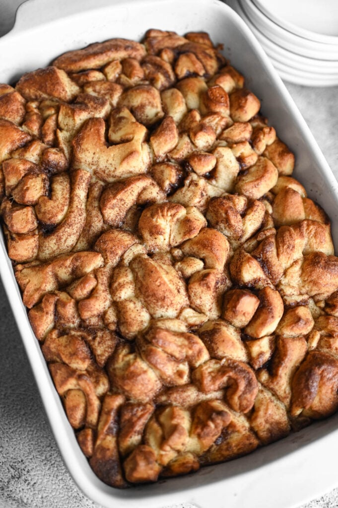 Baked cinnamon roll casserole, golden brown on top, before the frosting is added.