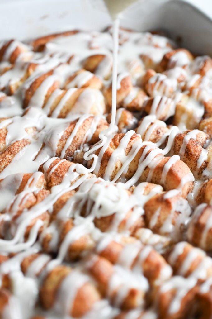 Frosting being drizzled on top of a casserole.