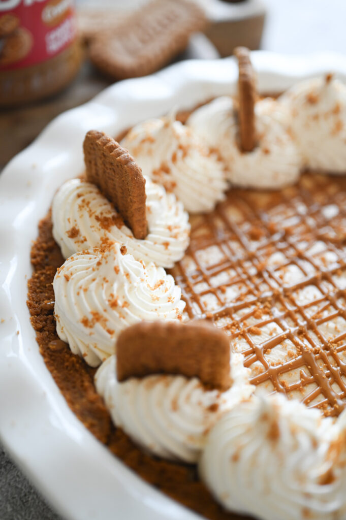 Close-up of the garnishes on top of a pie - whipped topping dollops, Biscoff cookie crumbs and Biscoff cookies.