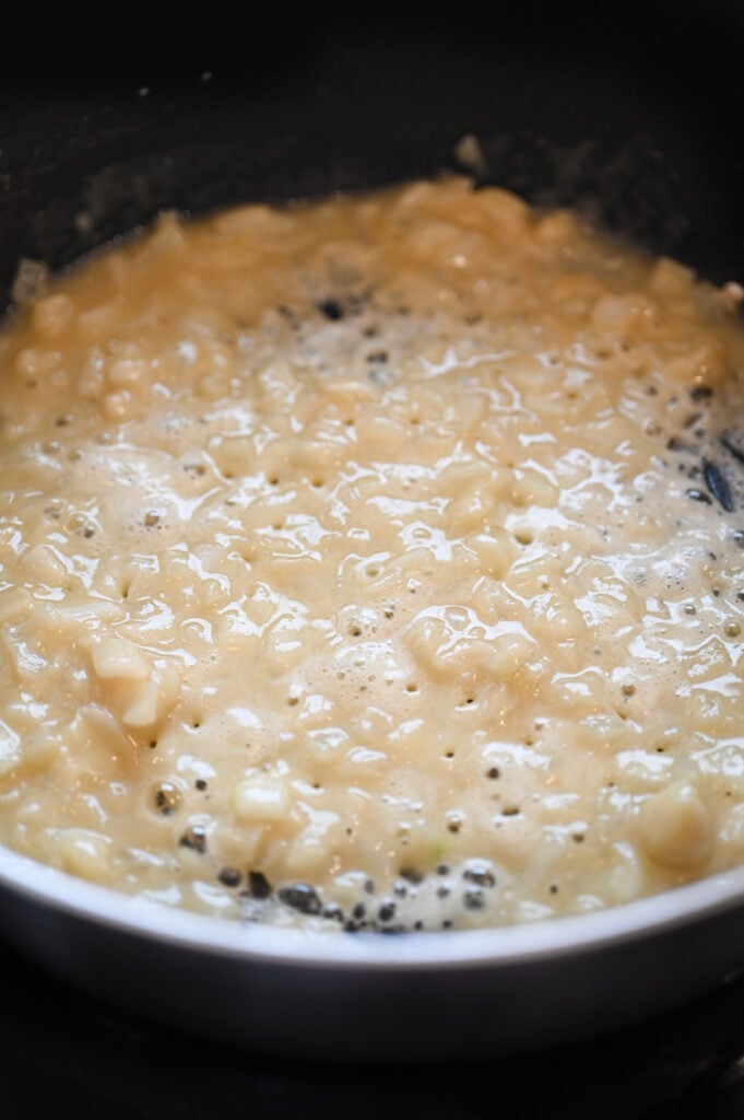 Butter, onions and flour being cooked in a sauté pan.