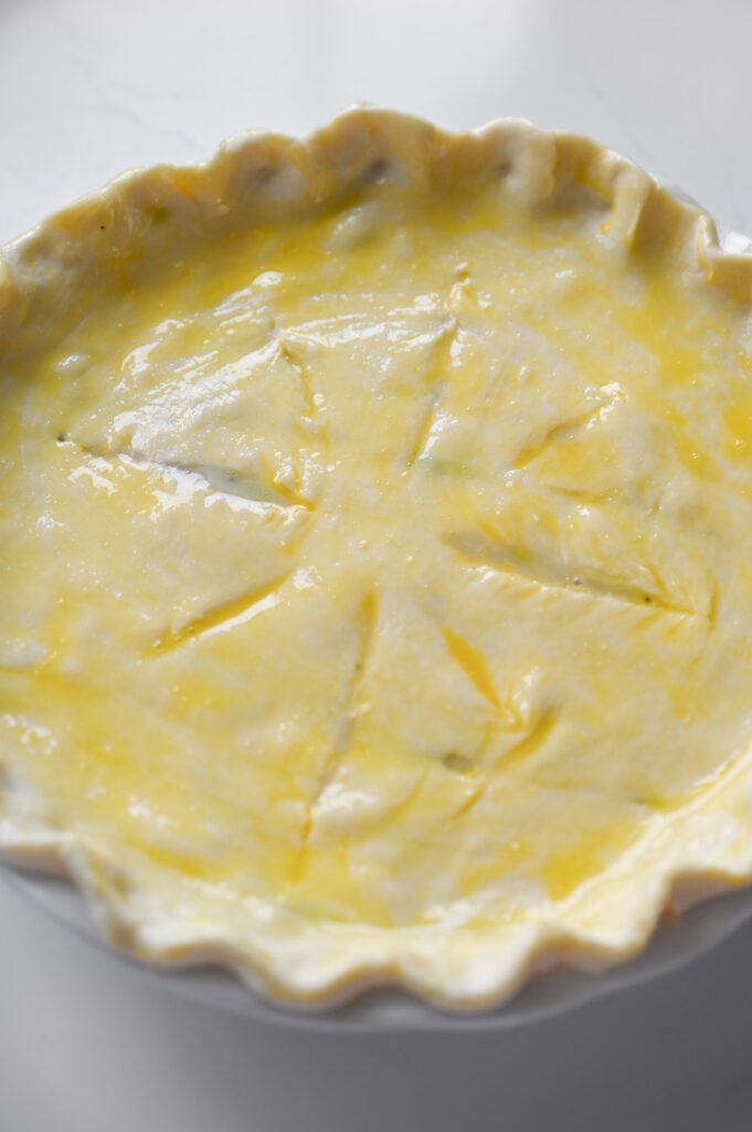 A pastry-topped pie with egg wash on top.
