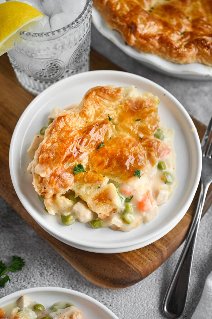 A plate with pot pie topped with puff pastry on it.