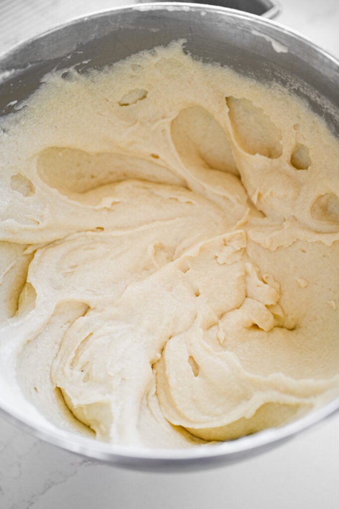 The bowl of a stand mixer with buttermilk cake batter in it.