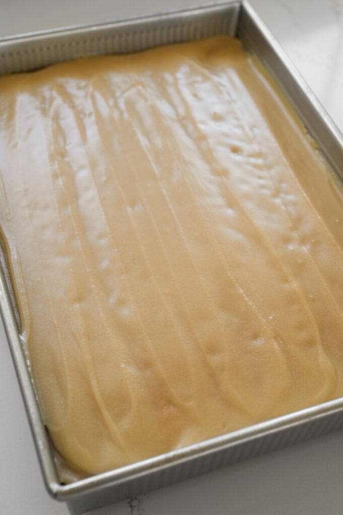 Icing spread over a 9x13-inch cake.