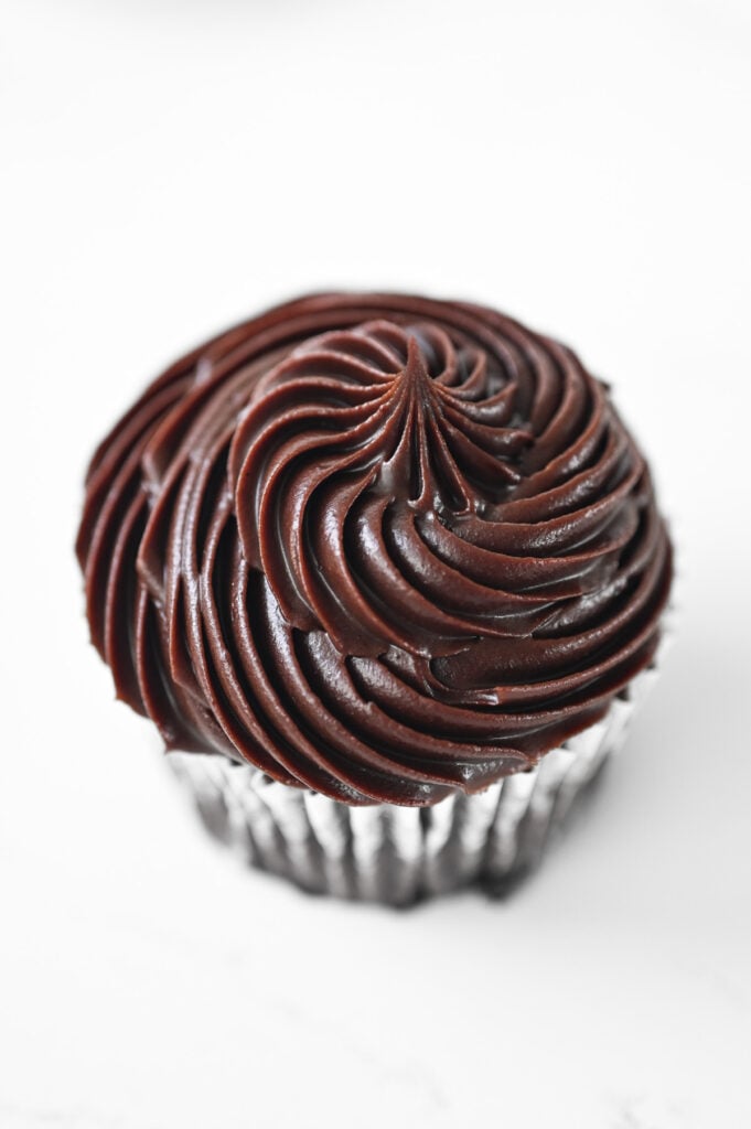 A chocolate cupcake with chocolate frosting.