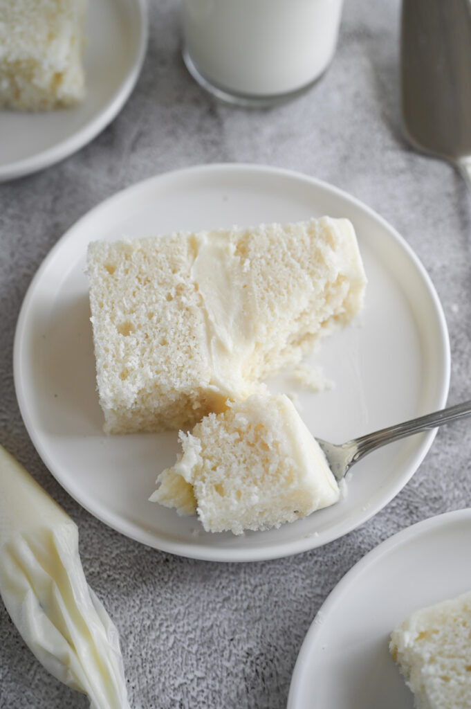 A slice of a 2-layer cake with a bite out of it.