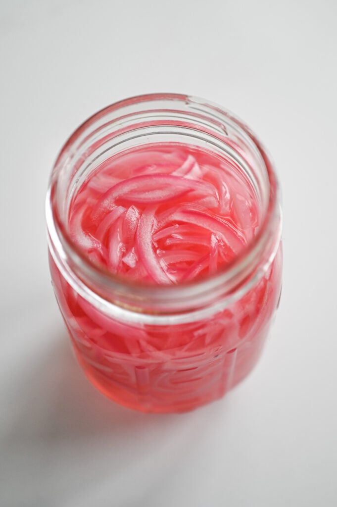 Pickled red onions in a jar.