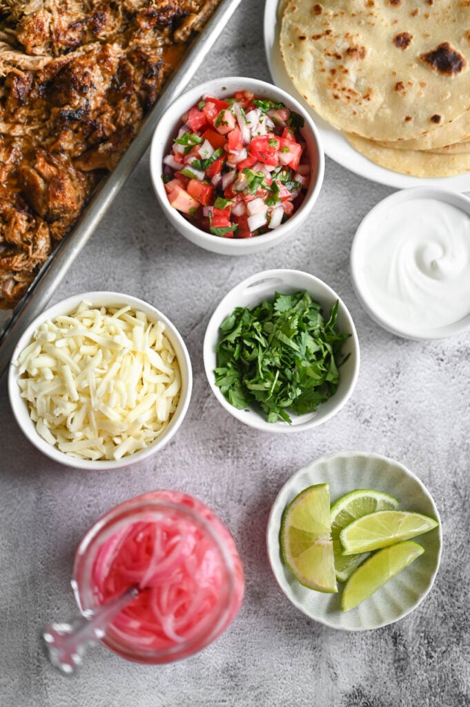 Many topping ideas for carnitas tacos.