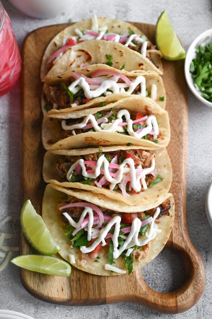 Four carnitas tacos with pickled red onions, pico de Gallo, sour cream, etc.