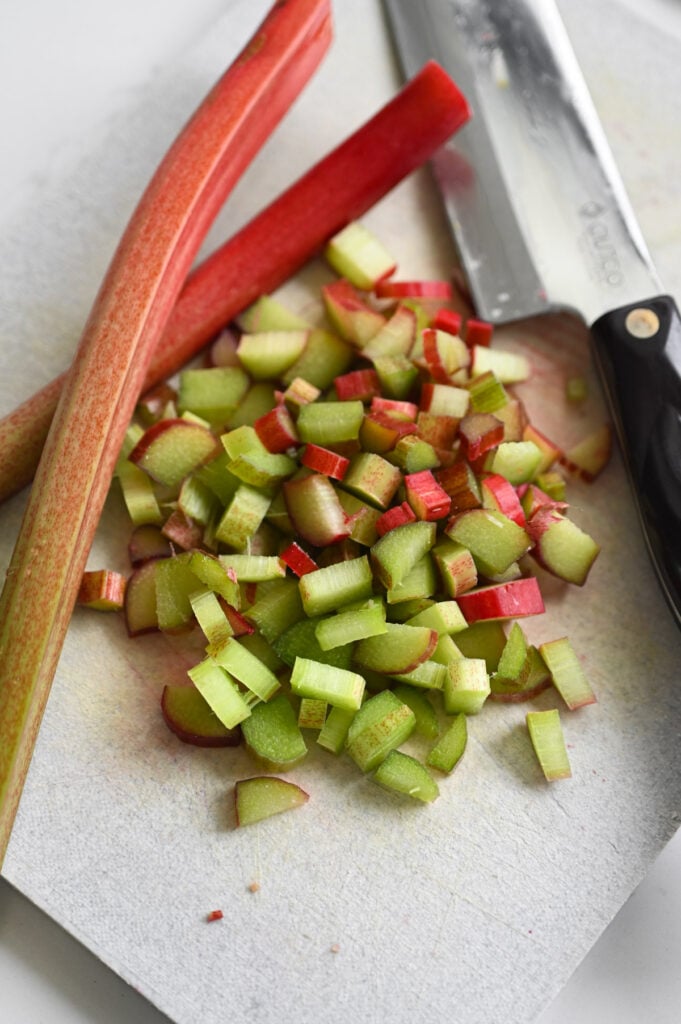 Rhubarb cut into small pieces on a cutting board.