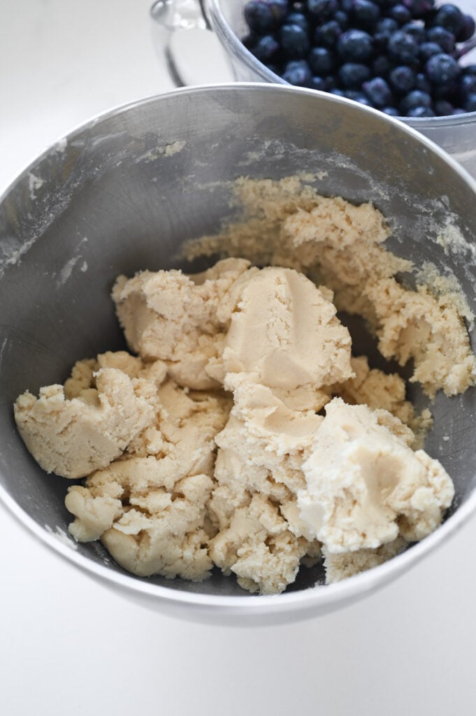 A sugar cookie dough in the bowl of a stand mixer.