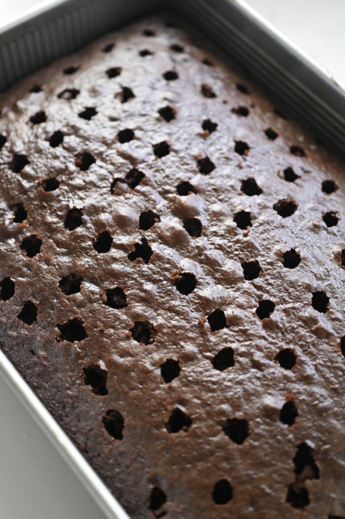 A chocolate cake with holes poked into it.