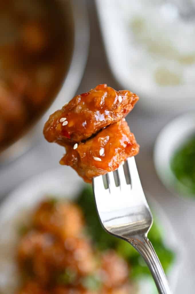 A fork holding two pieces of Sticky Pork.